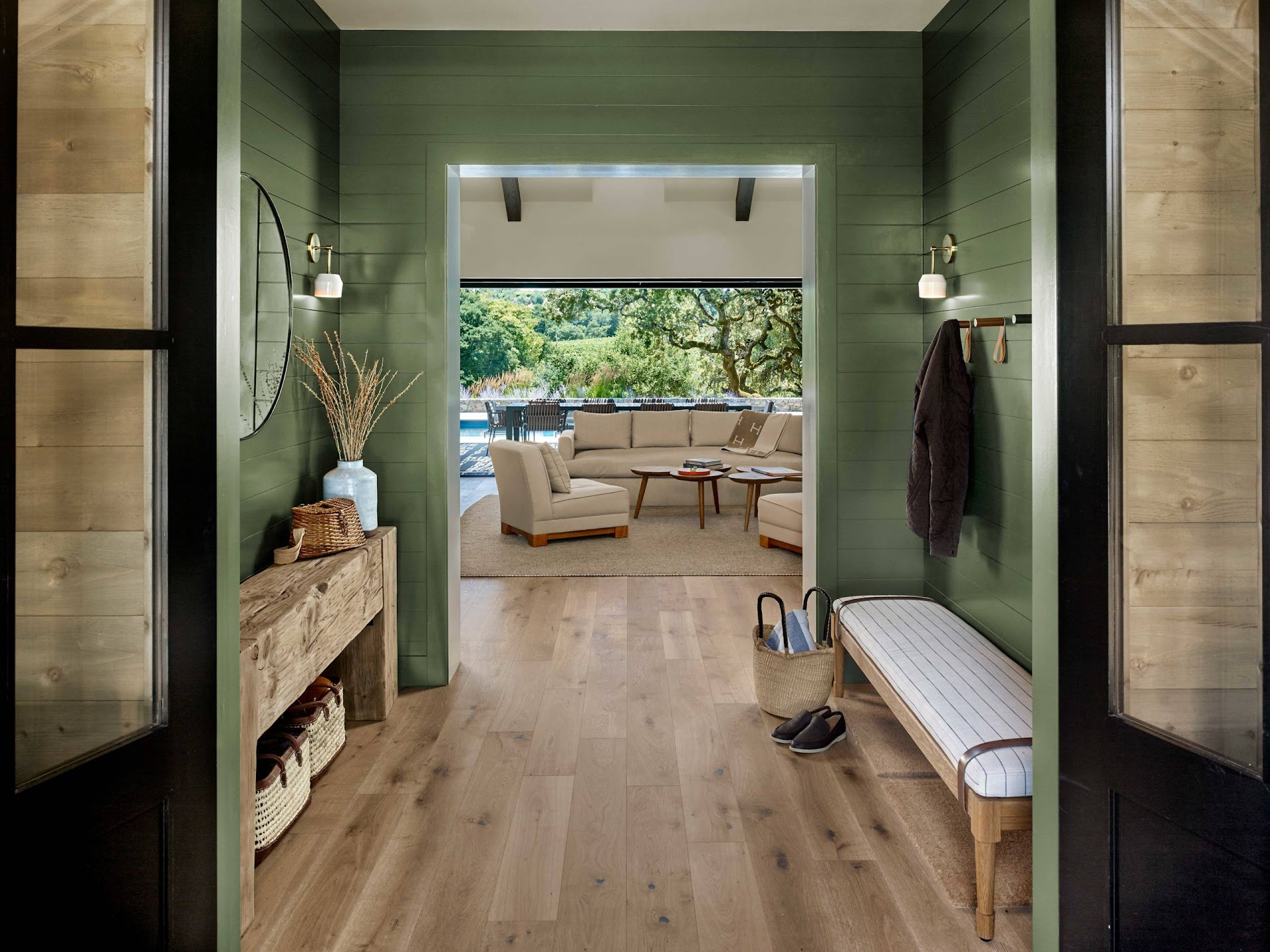 Interior designer curated entryway with matching finishing materials and complementary paint colors. Green entryway with natural finishes.